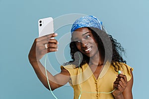 Young beautiful attractive long-haired curly smiling african woman taking selfie