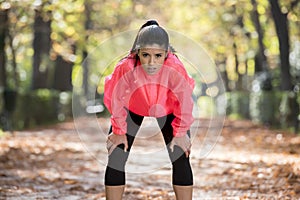 Attractive sport woman in runner sportswear breathing gasping and taking a break tired and exhausted after running workout on Autu