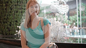 Young beautiful attractive woman sitting in shopping mall, smiling. Shopping consumerism concept.