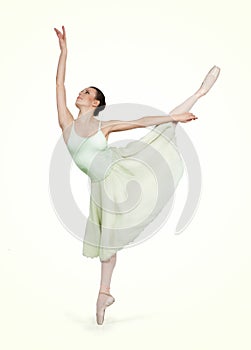 Young beautiful ballerina on a green background