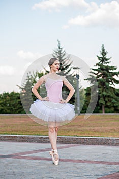 Young and beautiful ballerina posing on the street.