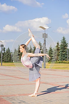 Young and beautiful ballerina posing on the street.