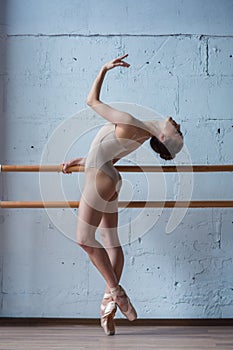 Young beautiful ballerina posing in studio