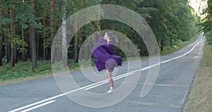 Young beautiful ballerina practicing stretching and exercises on the road