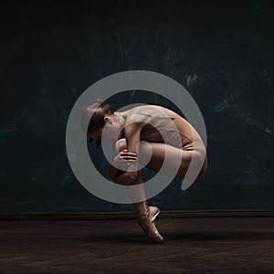 Young beautiful ballet dancer in beige swimsuit