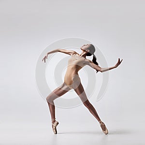 Young beautiful ballet dancer in beige swimsuit