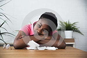 Young beautiful black woman suffering from depression sitting at her table at home and feels disappointed sad and depressed