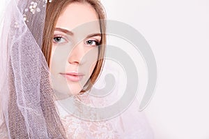 Young beautiful blond fiancee portrait with white veil/