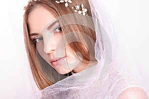 Young beautiful blond fiancee portrait with white veil.