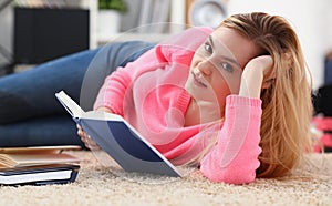 young beautiful blond woman lie on the floor read book