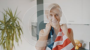 Young beautiful blond woman putting USA flag over her chests