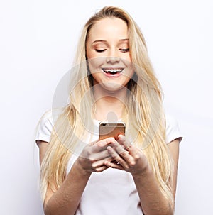 Young beautiful blond woman with smart phone, looks at the screen and is surprised