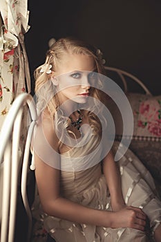 Young beautiful blonde in the bed at morning time near window un