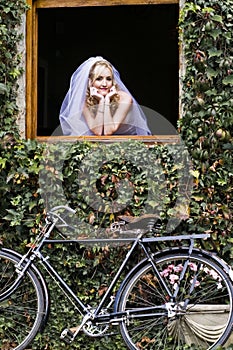 Young beautiful blonde bride looking out window