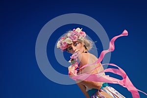 Young beautiful blonde bride in a wreath posing on the beach