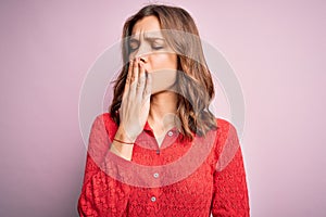 Young beautiful blonde casual girl over pink isolated background bored yawning tired covering mouth with hand