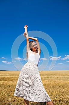 Young beautiful blonde girl posing in a wheat field