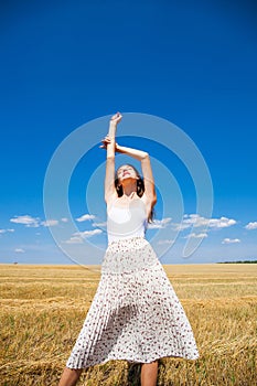 Young beautiful blonde girl posing in a wheat field