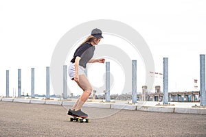 Young Beautiful Blonde Girl Riding Bright Skateboard on the Bridge