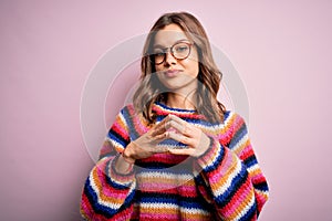 Young beautiful blonde girl wearing glasses and casual sweater over pink isolated background Hands together and fingers crossed