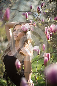 Young beautiful blonde woman in blooming garden. Beautiful natural woman with flowers. Spring girl portrait. Beauty