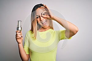 Young beautiful blonde woman holding led lightbulb over isolated white background with happy face smiling doing ok sign with hand