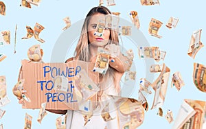 Young beautiful blonde woman holding power to the people cardboard banner pointing with finger to the camera and to you, confident