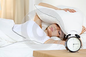 Young beautiful blonde woman lying in bed suffering from alarm c