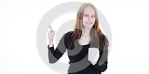 Young beautiful blonde woman presents mug white cup of coffee mockup pointing finger side an empty space