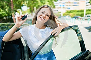 Young beautiful blonde woman smiling happy driving car