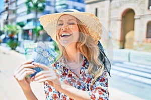 Young beautiful blonde woman on vacation wearing summer hat smiling happy