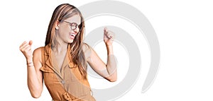 Young beautiful blonde woman wearing casual clothes and glasses dancing happy and cheerful, smiling moving casual and confident