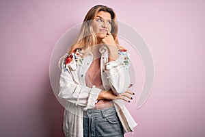 Young beautiful blonde woman wearing casual jacket standing over isolated pink background with hand on chin thinking about