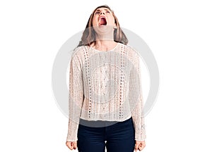 Young beautiful blonde woman wearing casual sweater angry and mad screaming frustrated and furious, shouting with anger