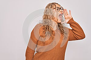 Young beautiful blonde woman wearing casual sweater and glasses over white background shouting and screaming loud to side with