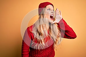 Young beautiful blonde woman wearing casual sweater and wool cap over white background shouting and screaming loud to side with