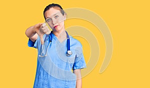 Young beautiful blonde woman wearing doctor uniform and stethoscope looking unhappy and angry showing rejection and negative with