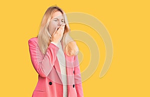 Young beautiful blonde woman wearing elegant clothes bored yawning tired covering mouth with hand