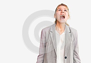 Young beautiful blonde woman wearing elegant jacket angry and mad screaming frustrated and furious, shouting with anger