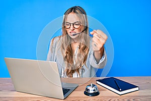 Young beautiful blonde woman wearing operator headset at the call center office annoyed and frustrated shouting with anger,