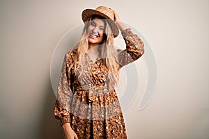 Young beautiful blonde woman wearing summer dress and hat over isolated white background confuse and wonder about question