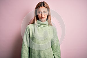 Young beautiful blonde woman wearing winter wool sweater over pink  background depressed and worry for distress, crying