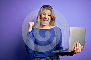 Young beautiful blonde woman working using laptop over isolated purple background pointing and showing with thumb up to the side