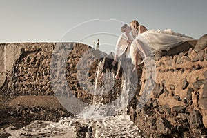 Young beautiful bridal couple having fun together at the beach