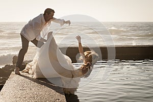 Young beautiful bridal couple having fun together at the beach