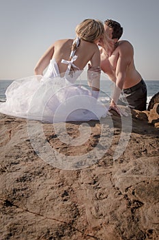 Young beautiful bridal couple having fun together at the beach