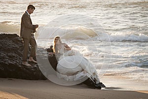 Young beautiful bridal couple having fun together at the beach