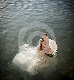 Young beautiful bridal couple having fun together at the beach