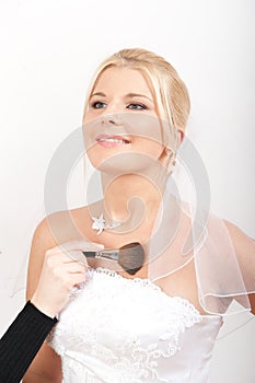 Young beautiful bride applying wedding make-up