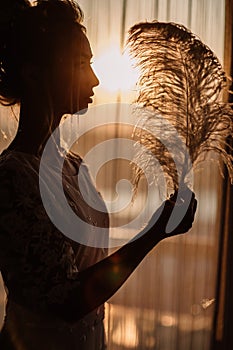 Young beautiful bride in boho style and white feathers